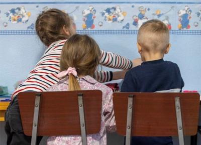 Imagen de tres niños de espaldas sentados en sillas | Foto de Fundación Banco Santander